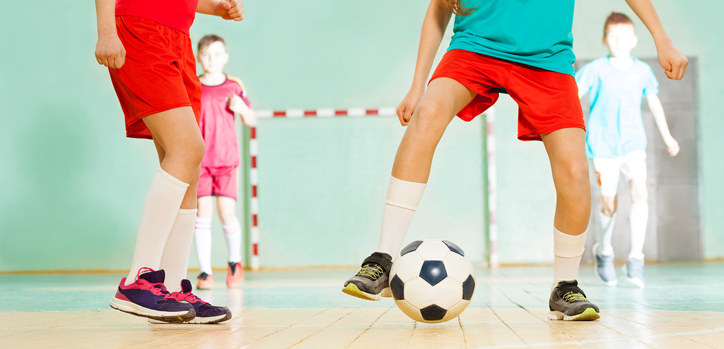 Børn spiller indendørs fodbold